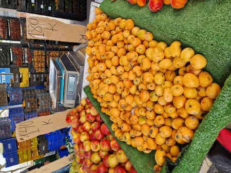 A variety of fruits, including apples, peaches, and apricots, are displayed on a market stall.の写真素材