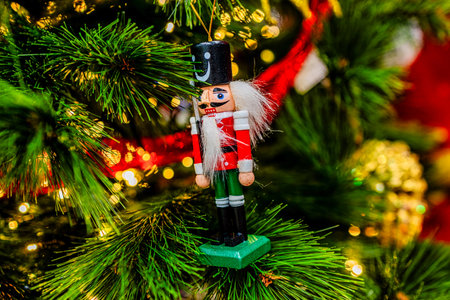 A festive nutcracker ornament hangs on a decorated Christmas tree,の写真素材