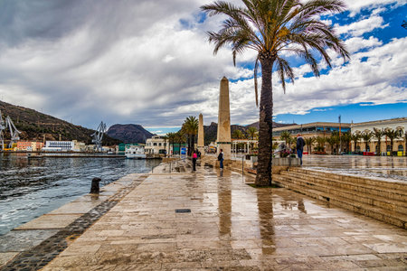 A bustling marina is filled with numerous sailboats, their masts reaching up towards a partly cloudy skyの写真素材