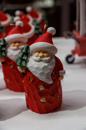 Santa Claus figurines are arranged in a festive display, each holding a small Christmas treeの写真素材