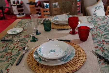 A beautifully set dining table features elegant dinnerware and glassware, along with a decorative candle as its centerpieceの写真素材