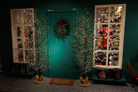 A charming entrance features a green door adorned with a festive wreath,の写真素材
