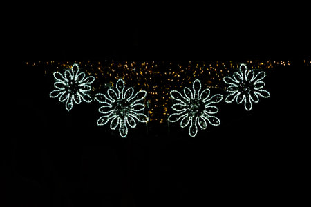 Twinkling christmas lights form the shape of four glowing snowflakesの写真素材