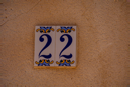 A ceramic tile with the number 22 is mounted on a textured wall.の写真素材