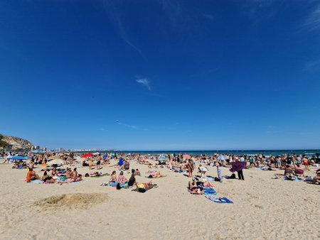 A lively beach scene shows people enjoying the sunの写真素材