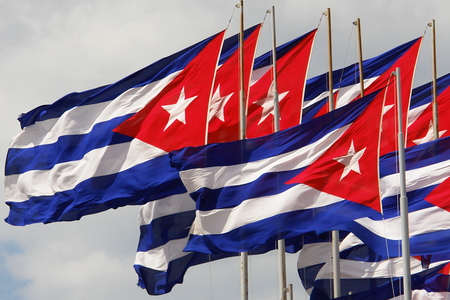 Cuban Flag On Flagpole Against Blue Sky With White Cloudsの写真素材