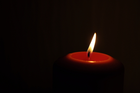 Burning candle on a dark blured backgroundの写真素材