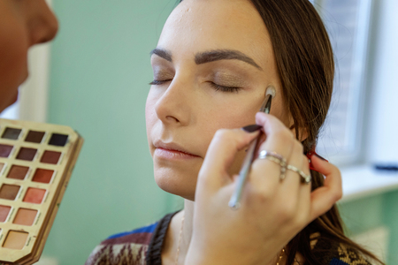 Closeup portrait of a woman having applied makeup by makeup artistの写真素材