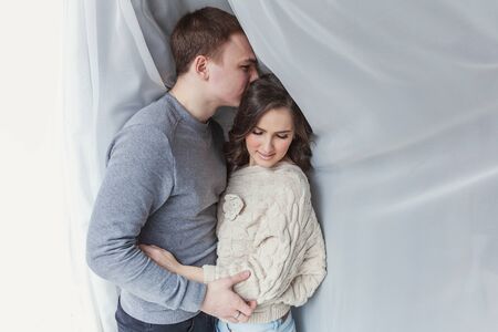 Couple in love having nice time together. Young happy woman hugging her handsome boyfriend. Cheerful...