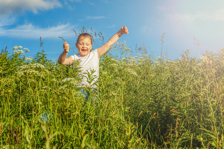 Happy cute little girl running on the grass in the park. Happiness. Healthy preschool children summer activity. Kids playing outdoorsの写真素材