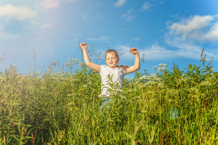 Happy cute little girl running on the grass in the park. Happiness. Healthy preschool children summer activity. Kids playing outdoorsの写真素材
