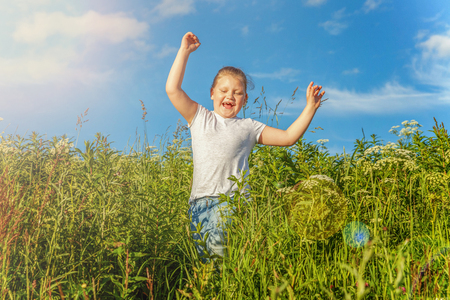Happy cute little girl running on the grass in the park. Happiness. Healthy preschool children summer activity. Kids playing outdoorsの写真素材