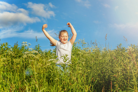Happy cute little girl running on the grass in the park. Happiness. Healthy preschool children summer activity. Kids playing outdoorsの写真素材