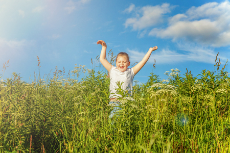 Happy cute little girl running on the grass in the park. Happiness. Healthy preschool children summer activity. Kids playing outdoorsの写真素材