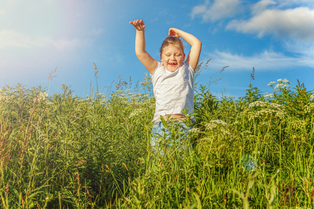 Happy cute little girl running on the grass in the park. Happiness. Healthy preschool children summer activity. Kids playing outdoorsの写真素材