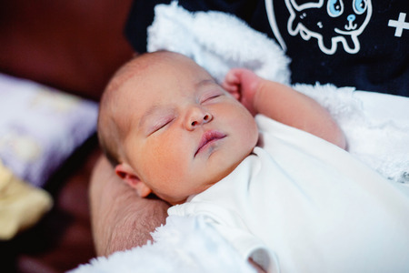 Soft portrait of peaceful sweet newborn infant baby lying on bed while sleeping in a bright room. Materinity family chilhood innocence care conceptの写真素材