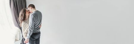 Couple in love having nice time together. Young happy woman hugging boyfriend, white background....