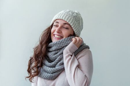 Beautiful woman winter portrait, true emotions. Laughing girl with long hair wearing warm clothes hat scarf isolated on white background. Young hipster girl looking happy and excited, having funの写真素材