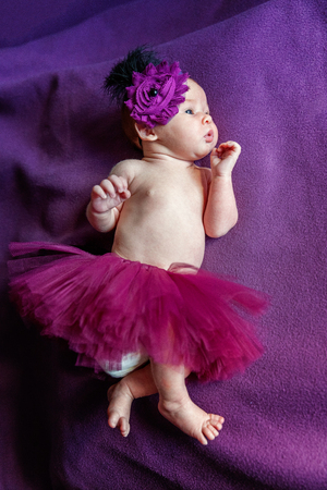 Soft portrait of peaceful sweet newborn infant baby lying on bed while sleeping in purple blanket background. Sweet dream, good night. Maternity family childhood innocence care conceptの写真素材