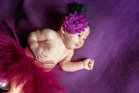 Soft portrait of peaceful sweet newborn infant baby lying on bed while sleeping in purple blanket background. Sweet dream, good night. Maternity family childhood innocence care conceptの写真素材