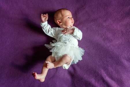 Soft portrait of peaceful sweet newborn infant baby lying on bed while sleeping in purple blanket background. Sweet dream, good night. Maternity family childhood innocence care conceptの写真素材