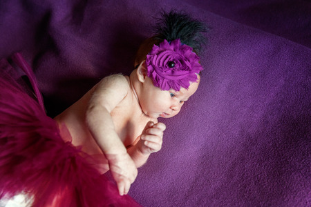 Soft portrait of peaceful sweet newborn infant baby lying on bed while sleeping in purple blanket background. Sweet dream, good night. Maternity family childhood innocence care conceptの写真素材
