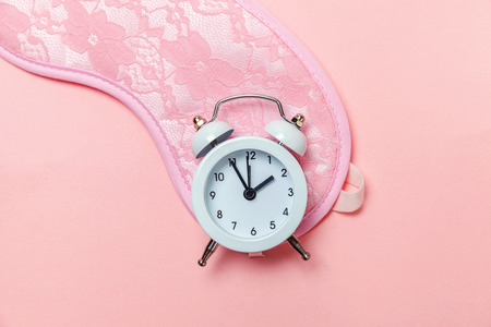 Do not disturb me, let me sleep. Sleeping eye mask, alarm clock isolated on pink pastel colourful trendy background. Rest, good night, siesta, insomnia, relaxation, tired, travel conceptの写真素材