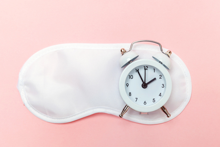 Do not disturb me, let me sleep. Sleeping eye mask, alarm clock isolated on pink pastel colourful trendy background. Rest, good night, siesta, insomnia, relaxation, tired, travel conceptの写真素材