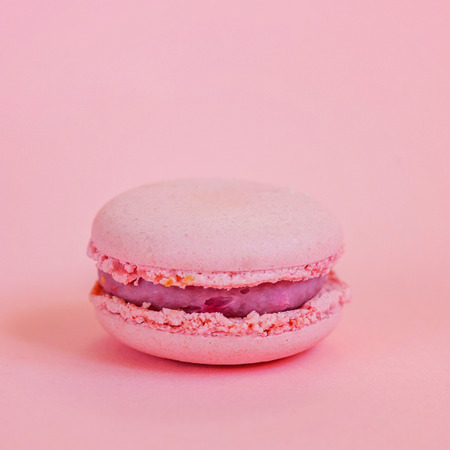 Sweet almond colorful unicorn pink macaron or macaroon dessert cake isolated on trendy pink pastel...