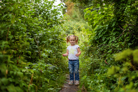 Portrait of happy cute little girl outdoor. Kid palying in park, garden, fairy forest. Happiness. Healthy preschool children summer activityの写真素材