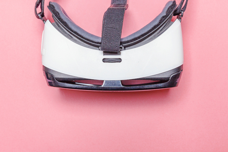 Minimal simple flat lay with virtual reality VR glasses helmet headset on pink pastel trendy background. Smartphone using with virtual reality goggles. Technology, simulation, hi-tech, videogame conceptの写真素材