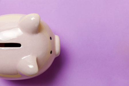 Saving investment budget wealth retirement financial money banking concept. Pink piggy bank isolated on purple violet pastel colourful trendy background. Flat lay top view copy spaceの写真素材