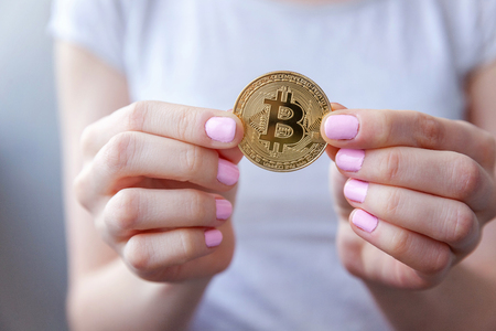 Cryptocurrency golden bitcoin coin in woman hand. Electronic virtual money for web banking and international network payment. Symbol of crypto currencyの写真素材
