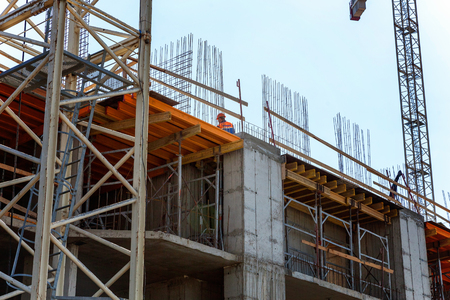 construction worker on construction site against blue sky. building house, shop, mall or shopping centerのeditorial素材