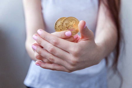 Cryptocurrency golden bitcoin coin in woman hand. Electronic virtual money for web banking and international network payment. Symbol of crypto currencyの写真素材