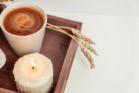 Natural eco home decor with cup coffee marshmallow candle on wooden tray. Early morning breakfast lifestyle background. Interior decoration with hot drink mug. Hygge scandinavian style copy spaceの写真素材
