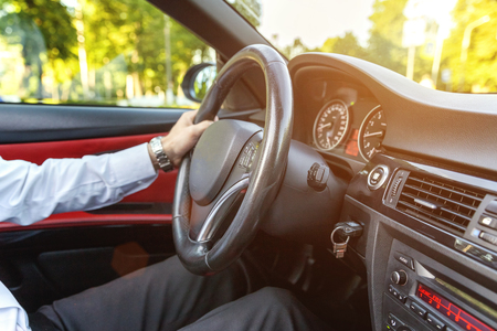 Male hands on steering wheel closeup. Sunny dayの写真素材