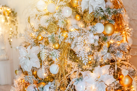Classic Christmas decorated New year tree. Christmas tree with gold decorations, toy and ball. Modern dark classical style interior design apartment. Christmas eve at homeの写真素材