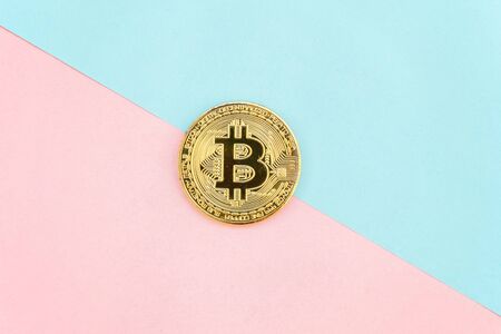 Gold bitcoin on on pink and blue pastel geometric background. Electronic virtual money for web banking and international network payment. Symbol of crypto currencyの写真素材
