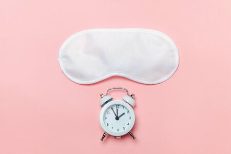 Do not disturb me, let me sleep. Sleeping eye mask, alarm clock isolated on pink pastel colourful trendy background. Rest, good night, siesta, insomnia, relaxation, tired, travel conceptの写真素材