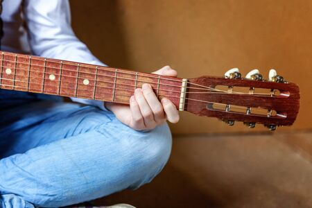 Young hipster woman hands playing guitar at home. Teen girl learning to play song and writing music in her room. Hobby, lifestyle, relax, Instrument, leisure, education conceptの写真素材