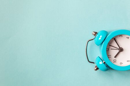 Ringing twin bell vintage classic alarm clock Isolated on blue pastel colorful trendy background....