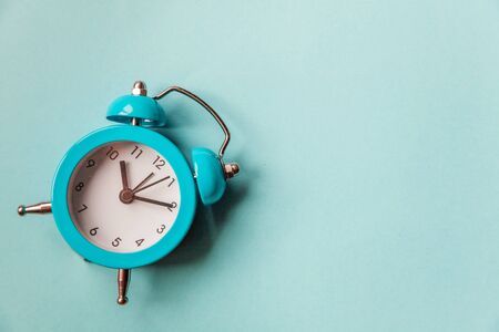 Ringing twin bell vintage classic alarm clock Isolated on blue pastel colorful trendy background. Rest hours time of life good morning night wake up awake concept. Flat lay top view copy spaceの写真素材