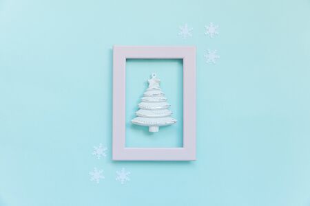 Simply minimal composition winter objects ornament fir tree in pink frame isolated on blue pastel trendy background. Christmas New Year december time for celebration concept. Flat lay top viewの写真素材