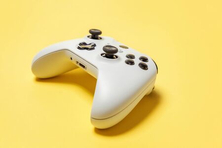 White joystick gamepad, game console on yellow colourful trendy modern fashion pin-up background....