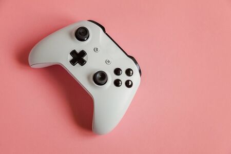 White joystick gamepad, game console on pastel pink colourful trendy modern pin-up background....
