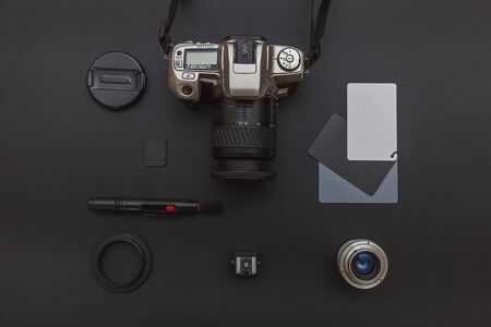 Photographer workplace with dslr camera system, camera cleaning kit, lens and camera accessory on dark black table background. Hobby travel photography concept. Flat lay top view copy spaceの写真素材