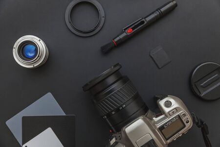 Photographer workplace with dslr camera system, camera cleaning kit, lens and camera accessory on dark black table background. Hobby travel photography concept. Flat lay top view copy spaceの写真素材