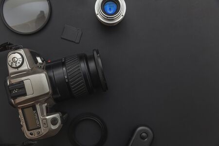 Photographer workplace with dslr camera system, camera cleaning kit, lens and camera accessory on...