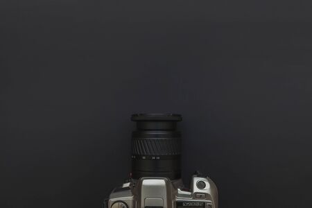 Photographer workplace with dslr camera system on dark black table background. Hobby travel photography concept. Flat lay top view copy spaceの写真素材
